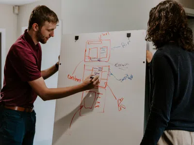 Ein Digital Transformation Manager schreibt mit einem Marker auf eine weiße Tafel.