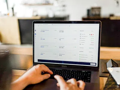 Ein auf Big Data Management spezialisierter Experte, der an einem Tisch auf einem Laptop tippt.