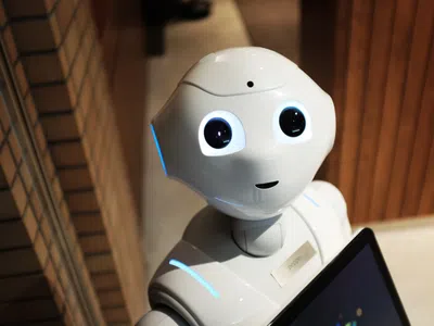 Ein weißer Roboter mit einem Laptop in der Hand