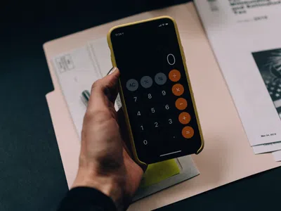 Eine Person, die ein Mobiltelefon in der Hand hält und als Finanz- und Buchhaltungsmanager arbeitet.