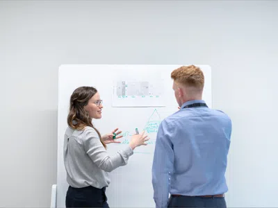 Logistik- und Supply-Chain-Manager stehen vor einem Whiteboard.