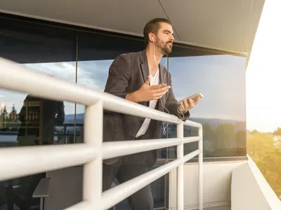 Marketing- und Vertriebsmanager: beim Telefonieren auf dem Balkon.