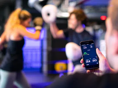 Ein Experte für Sportpsychologie hält ein Mobiltelefon in der Hand.