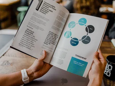 Spezialist:in für digitale Geschäftsmodelle hält ein aufgeschlagenes Buch.