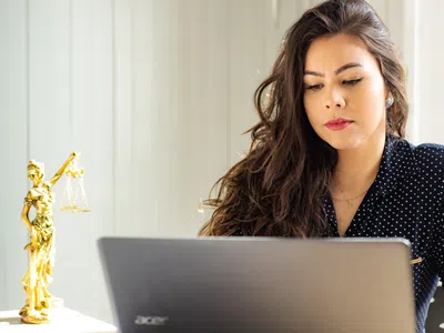 Spezialist:in internationales Recht arbeitet am Laptop.