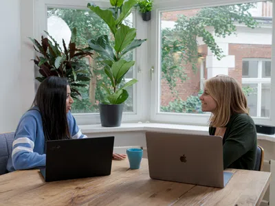 Eine Talentmanagerin und ihr Team sitzen mit Laptops an einem Tisch.