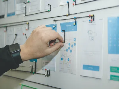 Ein Usability-Experte pinnt Post-ist an ein Whiteboard