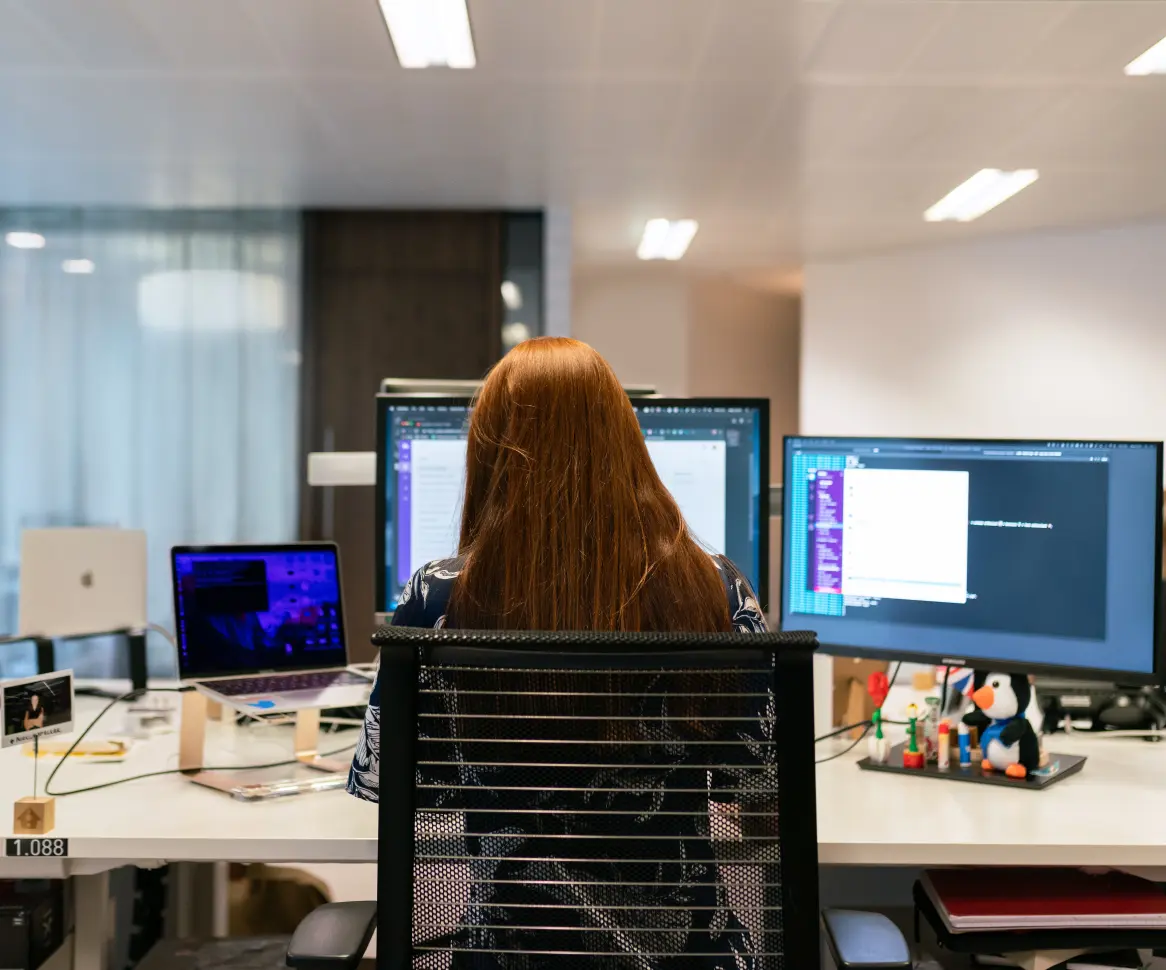 Ein Data Science-Student sitzt vor seinem Laptop und sein Betreuer schaut ihm über die Schulter.  