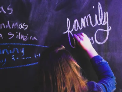 Eine Englischlehrerin schreibt etwas an eine Tafel