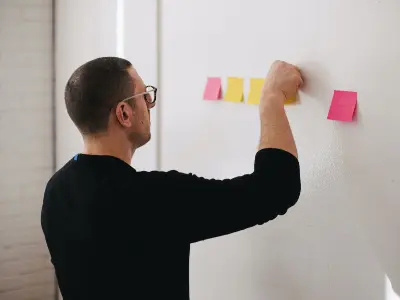 Ein Spezialist für Produktionsoptimierung klebt Post-its an die Wand